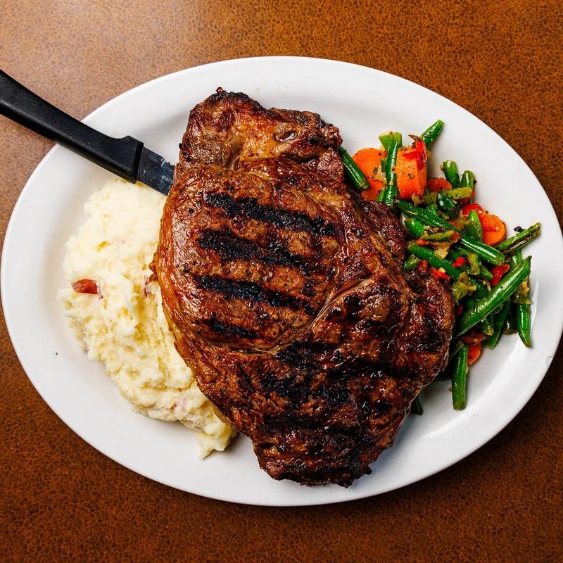 Corte de res a la parrilla servido con puré y verduras